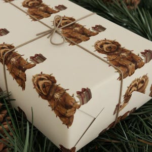 May include: Gift-wrapped present featuring a repeating pattern of brown dogs adorned with string lights and small gift boxes on a cream background. The package is tied with twine. The theme is festive and holiday-oriented.