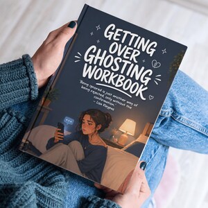 Puede incluir: Un libro titulado "Getting Over Ghosting Workbook" sostenido por una persona. La portada es azul oscuro con texto blanco y una ilustraci&oacute;n de una persona en una cama mirando un tel&eacute;fono. La persona lleva un su&eacute;ter azul y vaqueros.