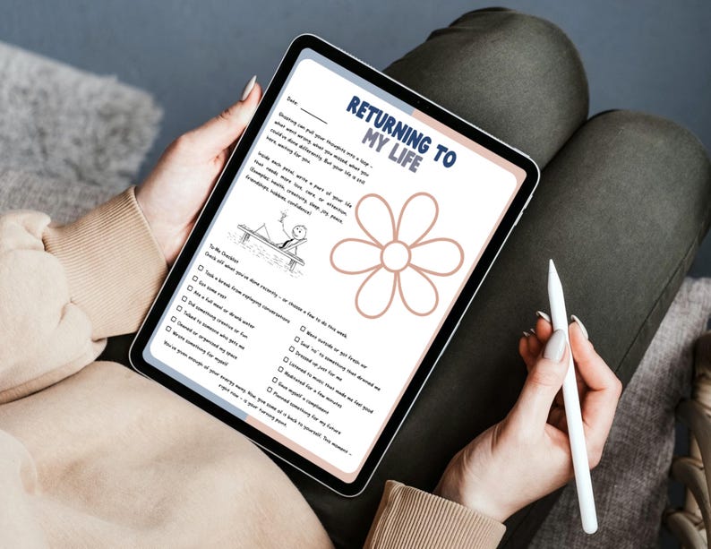 Puede incluir: Una tableta digital que muestra una hoja de trabajo de autorreflexi&oacute;n titulada "Returning to My Life". La hoja de trabajo incluye una ilustraci&oacute;n de una flor y indicaciones de lista de verificaci&oacute;n. Un l&aacute;piz &oacute;ptico blanco descansa cerca de la tableta.
