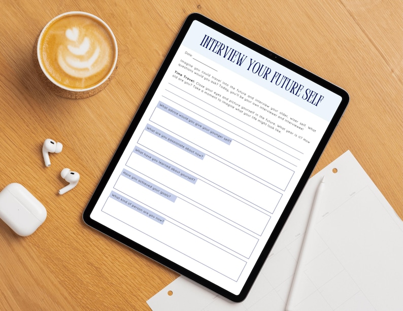 Pu&ograve; includere: Un tablet digitale che mostra un foglio di lavoro intitolato "Intervista il tuo futuro s&eacute;" con suggerimenti. Una tazza di caff&egrave; con latte art, auricolari wireless e una custodia di ricarica sono su una superficie di legno.
