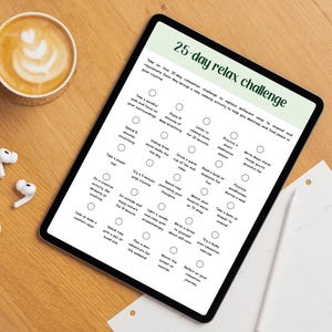May include: A digital tablet shows a 25-day relax challenge with wellness activities. A coffee with latte art, wireless earbuds, and a charging case are on a wooden surface.
