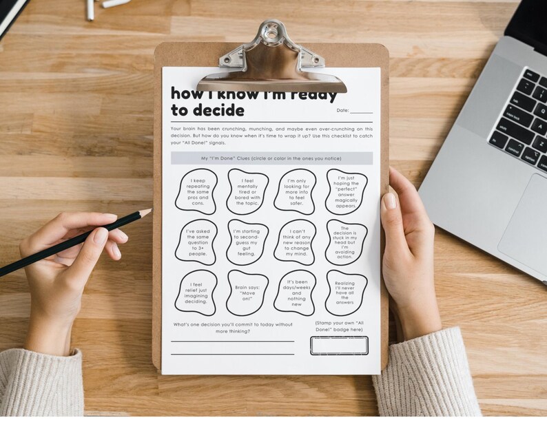 May include: A clipboard with a printed checklist titled "how I know I'm ready to decide" is held by a person. The checklist includes prompts to help with decision-making. A laptop and pencil are also visible.