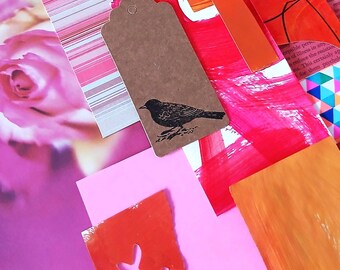 Pode incluir: Uma colagem de elementos de papel com uma etiqueta de papel kraft castanho com uma silhueta de pássaro preta, imagens de rosas cor-de-rosa, papel às riscas, secções pintadas de laranja e vermelho vivo, círculos recortados amarelos e cor-de-rosa.