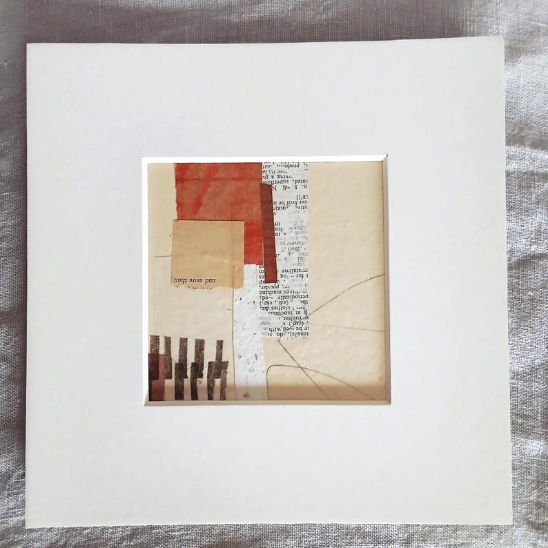 May include: Abstract mixed media artwork in a white mat. The artwork features torn paper elements in beige, red, and brown, with text fragments and linear details. The words "and more than" are visible.