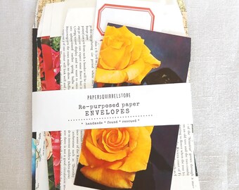 Pode incluir: Um conjunto de envelopes de papel reutilizado, presos por uma faixa branca. Os envelopes incluem mapas vintage, imagens florais e etiquetas em branco. A faixa apresenta o texto "PAPERSQUIRRELSTORE Re-purposed paper ENVELOPES handmade * found * rescued *."