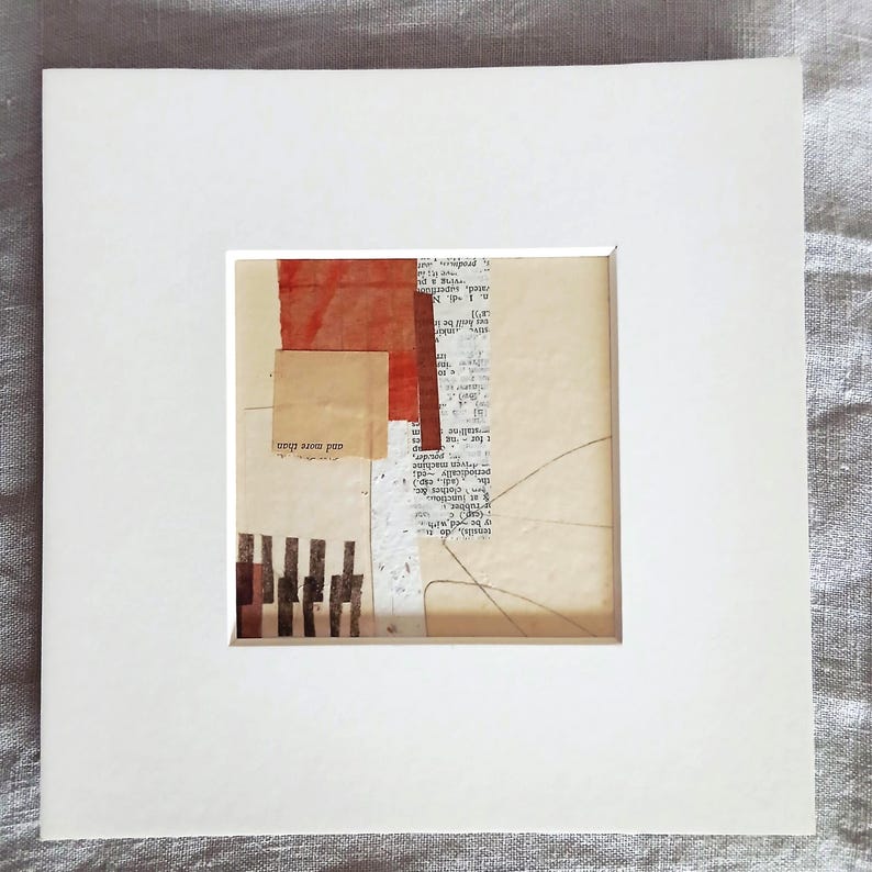 May include: Abstract collage artwork in a white mount. The artwork uses layered paper elements in beige, red, and brown tones. Some areas include text fragments and linear details, creating a collage effect. The words "and more than" are visible.