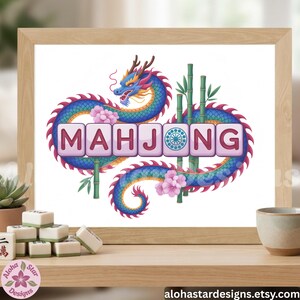May include: A framed print featuring the word "MAHJONG" in pink tiles, with a blue and purple dragon design. Bamboo stalks and pink flowers surround the text. Mahjong tiles are visible on a wooden shelf, with the Aloha Star Designs logo.