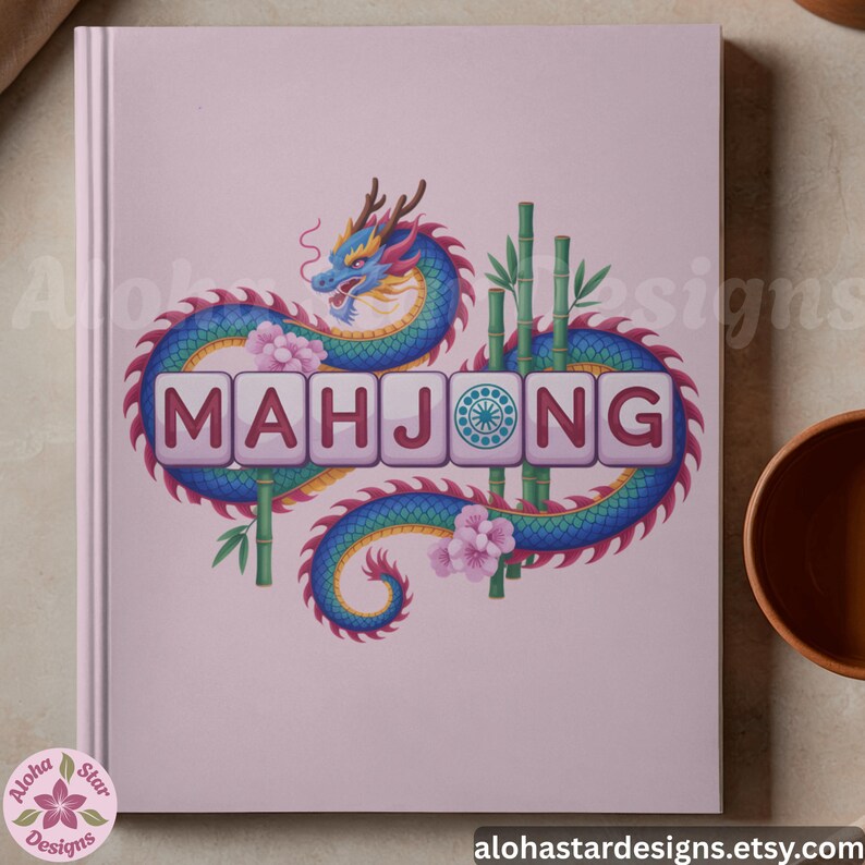 May include: A light pink notebook featuring a colorful illustration of a dragon wrapped around the word "MAHJONG" in white tiles. Bamboo stalks and pink flowers accent the design. The Aloha Star Designs logo is in the lower left corner.