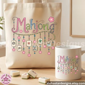 May include: A beige tote bag and white mug with the word "Mahjong" in pink, blue, and green script. The design includes hanging tiles and pink flowers. Several Mahjong tiles are on the table.