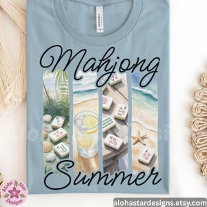 May include: Pale blue t-shirt with a graphic design. The design shows the words "Mahjong Summer" in a cursive font, a beach scene, mahjong tiles, a drink with lemon slices, and seashells.