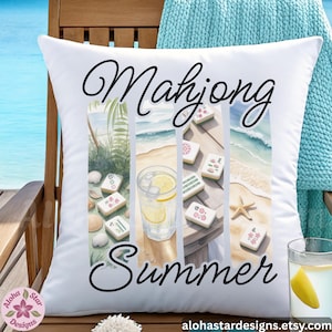 May include: White square cushion with the words "Mahjong Summer" in black script. The cushion features a watercolour design of mahjong tiles, a beach scene, and a glass of lemonade. The cushion is on a wooden chair.