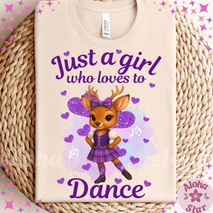 May include: Beige t-shirt with a cartoon deer wearing a purple plaid dress and bow. The text "Just a girl who loves to dance" is in purple script. Purple hearts and musical notes decorate the design.
