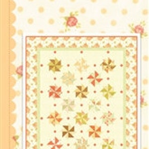May include: A fabric pattern book titled "Poger Roses" by Fig Tree & Co. The cover features a quilt design with pinwheel blocks in shades of peach, cream, and gold, set against a dotted background with floral accents. The book is square-shaped.