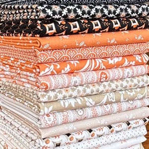 May include: A stack of patterned fabric in various colors and designs. The fabrics include black and white floral, orange and white leaf patterns, and tan and white floral prints. The fabrics are neatly folded and stacked.