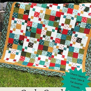 May include: A colorful patchwork quilt with a "Rocky Road" design, featuring squares of red, green, blue, and yellow fabrics. The quilt is bordered with a patterned fabric and a gold trim. The image includes the text "Sweet Jane's Quilting & Design."