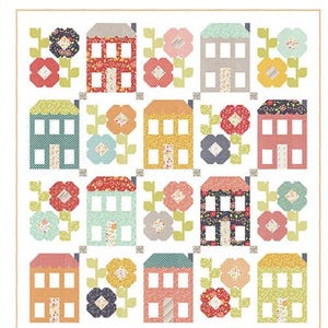 May include: A colorful quilt pattern titled "Spring Town" featuring rows of houses and flowers in various colors. The houses have windows and patterned roofs. The design includes the text "Chelsi Stratton Designs" and "Layer Cake Friendly".