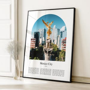 Può includere: Una stampa incorniciata con una fotografia di Città del Messico. L'immagine mostra la statua dorata dell'Angelo dell'Indipendenza sullo sfondo di moderni grattacieli sotto un cielo blu. Le parole "Mexico City" sono stampate in basso.