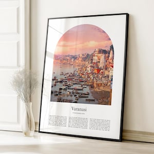 May include: Framed art print featuring a vibrant scene of Varanasi, India, with a sunset sky. The image, set within an arch, shows a river filled with boats, buildings, and the text "Varanasi, Uttar Pradesh, India". The print is in a black frame.