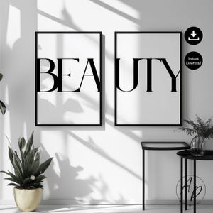 Könnte beinhalten: Zwei gerahmte Schwarz-Weiß-Drucke mit dem Wort „BEAUTY“ in fetter, eleganter Schrift. Die Drucke werden an einer weißen Wand mit einem schwarzen Beistelltisch und einer Topfpflanze im Vordergrund angezeigt. Die Gesamtästhetik ist minimalistisch und modern.