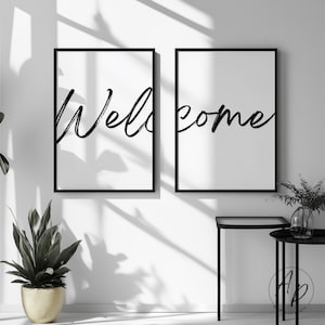 Könnte beinhalten: Zwei gerahmte Kunstdrucke mit dem Wort "Welcome" in schwarzer Schrift auf weißem Hintergrund. Die Rahmen sind schwarz und hängen an einer weißen Wand. Eine Topfpflanze und ein kleiner Tisch befinden sich im Vordergrund.
