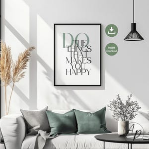 Könnte beinhalten: Ein gerahmter Druck mit dem Text "DO THE THINGS THAT MAKES YOU HAPPY" in Schwarz und Grün. Der Druck wird über einem weißen Sofa mit grauen und grünen Kissen angezeigt. Eine moderne schwarze Lampe hängt von der Decke.