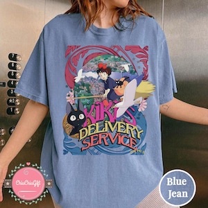May include: Pale blue t-shirt with a vibrant graphic from "Kiki's Delivery Service." The design shows Kiki on a broom, a black cat, and the words "Kiki's Delivery Service."