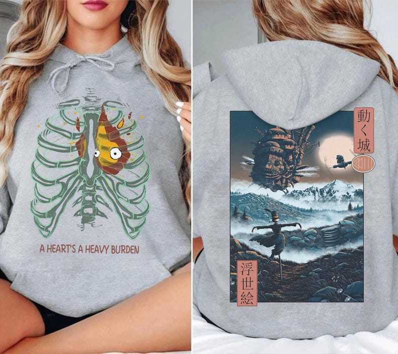 May include: Gray hoodie featuring a cartoon heart inside a rib cage with the text "A Heart's A Heavy Burden" on the front. The back of the hoodie has a colorful illustration with Japanese text.
