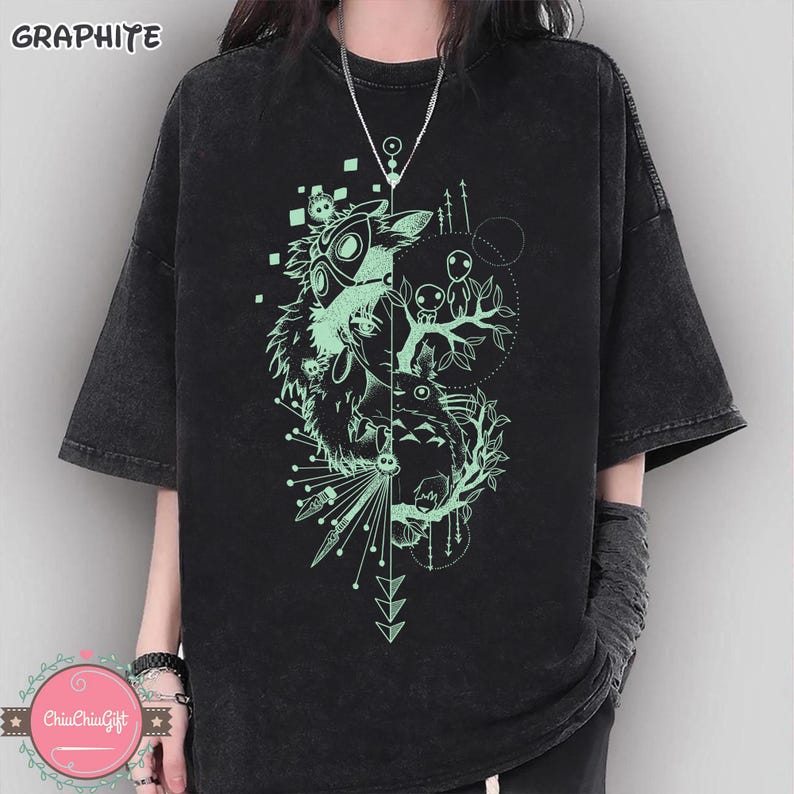 Puede incluir: Camiseta de color grafito con un dise&ntilde;o gr&aacute;fico &uacute;nico. El dise&ntilde;o presenta una imagen dividida con un esp&iacute;ritu del bosque y otros personajes en color verde claro. La camiseta tiene mangas cortas y un corte relajado.