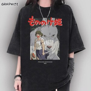 May include: Black graphic t-shirt with a design from the animated film Princess Mononoke. The illustration includes Japanese text, a wolf, and a female character. The text "PRINCESS MONONOKE 1997" is printed below the illustration.