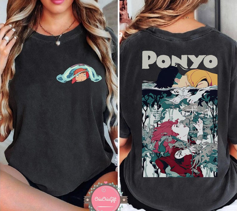 May include: Dark gray t-shirt featuring a front graphic of a cartoon character under a blue and green blanket. The back of the shirt displays the word "PONYO" above a colorful illustration of characters in an underwater scene.