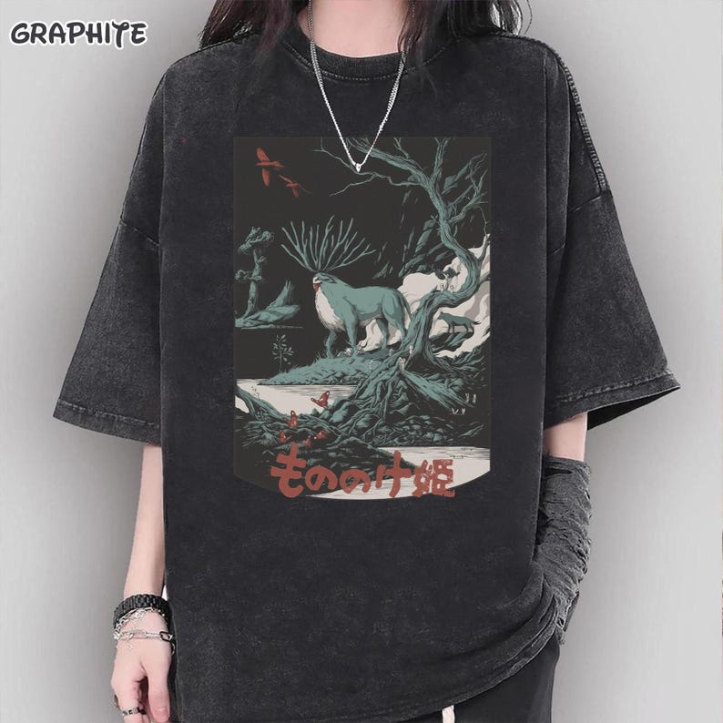 May include: Graphite-colored t-shirt featuring a detailed graphic of a deer-like creature in a forest setting. The design includes Japanese text and a dark, artistic aesthetic. The shirt has short sleeves and a relaxed fit.