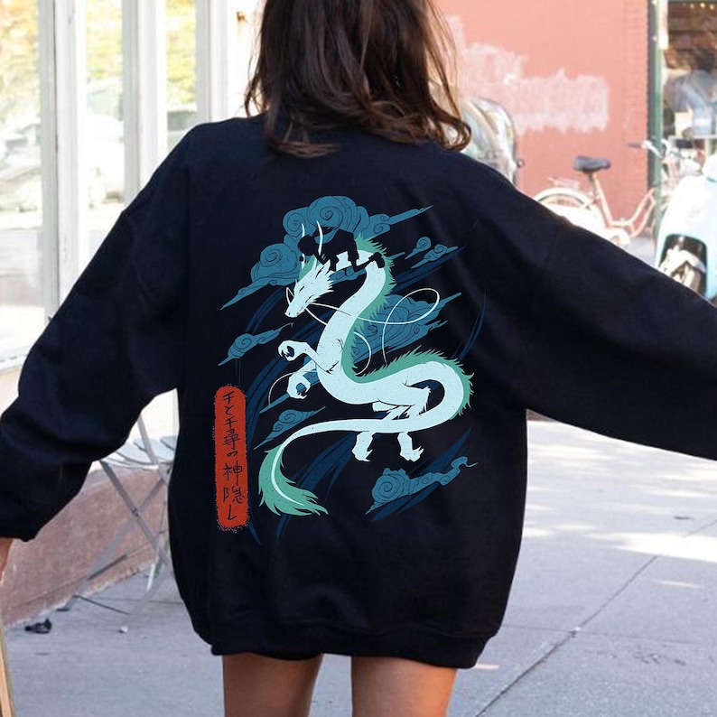 May include: Black sweatshirt featuring a light blue and green dragon design with cloud accents. Japanese text is visible on the left side of the dragon. The sweatshirt is a casual style.