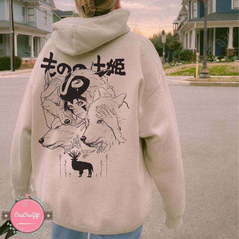 May include: Beige hoodie with a black graphic on the back featuring a stylized illustration of a woman, wolves, and a deer. Japanese text is above the illustration. The hoodie has a hood and long sleeves.