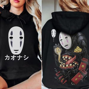 May include: Black hoodie featuring a white and gray graphic of a character from Spirited Away, with Japanese text. The back of the hoodie displays a larger illustration of the character with additional Japanese text and imagery.