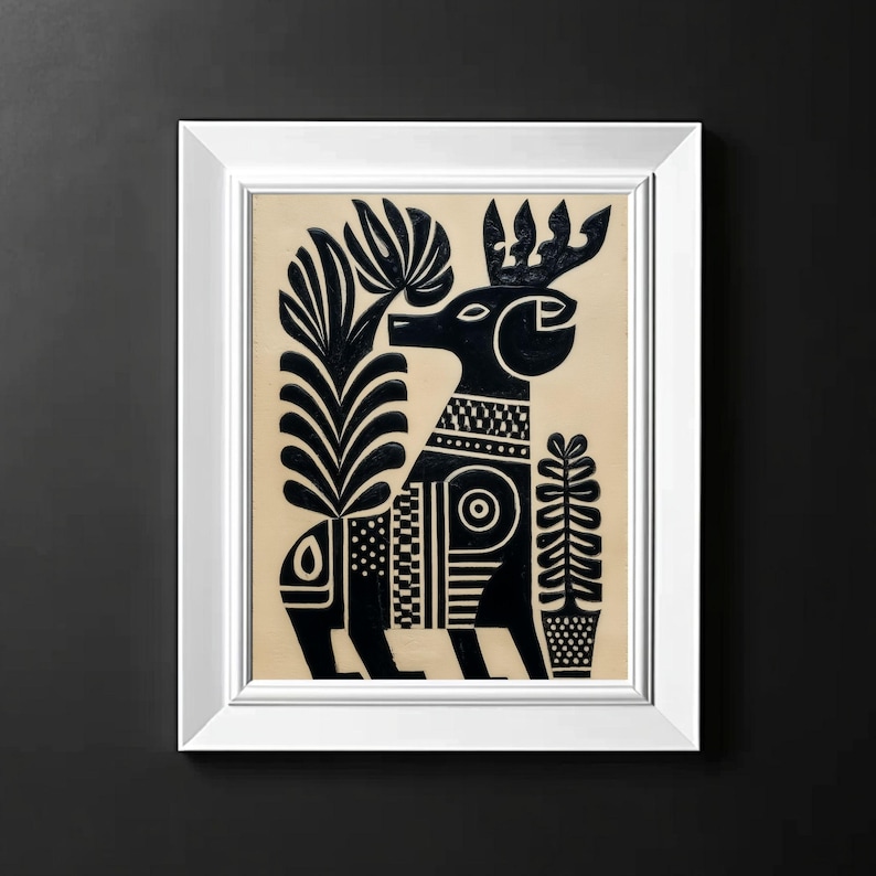 May include: A framed black and white folk art print featuring a stylized deer with elaborate patterns and plant motifs. The artwork is set against a beige background and framed in a white rectangular frame. The deer has a decorative collar and antlers.