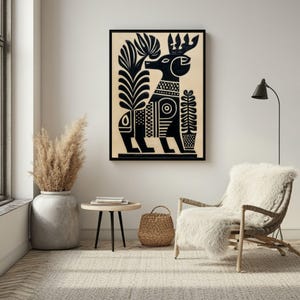 May include: Black and white framed art print featuring a stylized deer with a crown and geometric patterns. The artwork includes plant-like elements and is set against a beige background. The print is displayed in a modern living space.