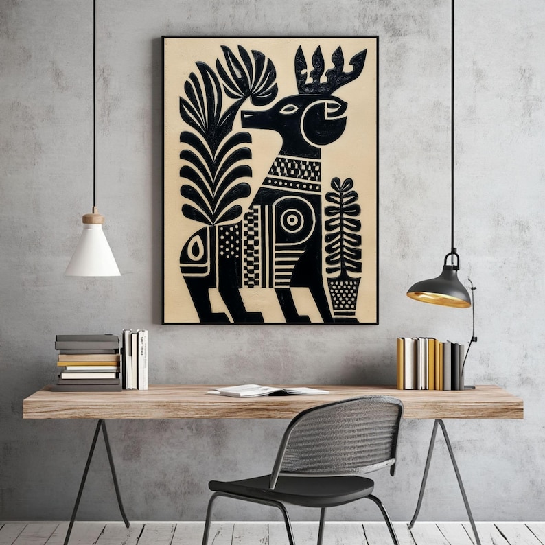 May include: Black and beige framed art print featuring a stylized deer with intricate patterns and floral elements. The artwork has a folk art style, with a black deer figure and plant designs on a beige background. The print is displayed on a wooden desk.