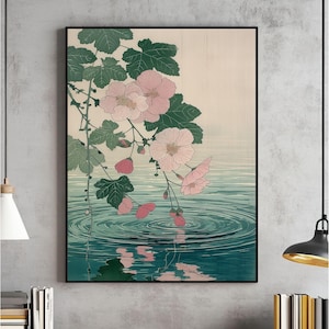 May include: A framed art print with a Japanese-inspired illustration. Pink flowers and green leaves cascade over teal water with circular ripples. The background is a pale beige colour.