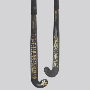 May include: Two black field hockey sticks with gold accents. The sticks have the brand name "OSAKA" in gold lettering. The grips are black, and the stick heads have a curved design. The background is a solid light gray.