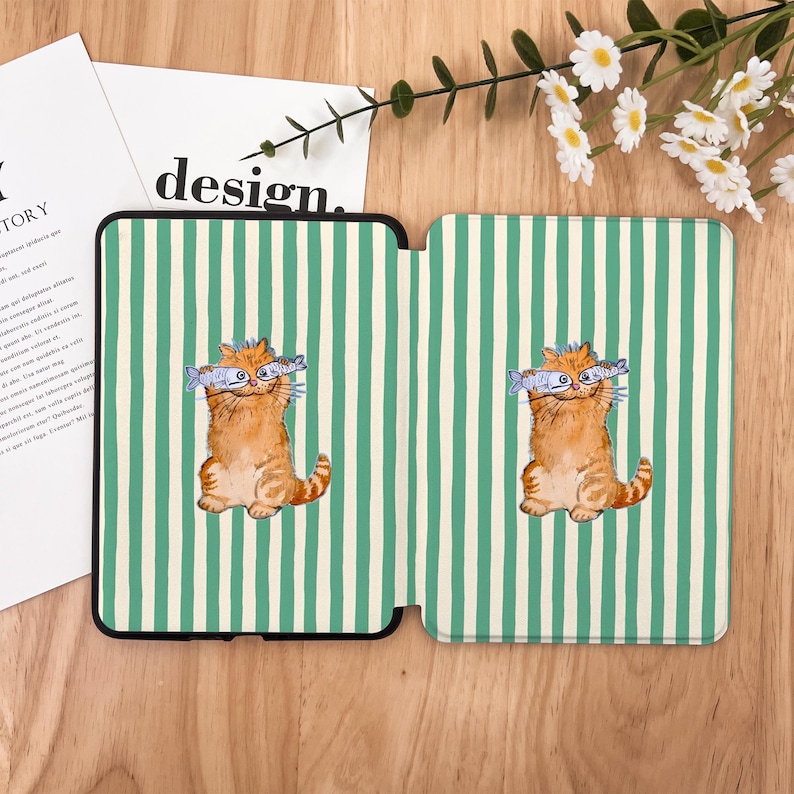 May include: A green and white striped kindle cover with a cartoon orange cat holding two fish in its mouth. The cat is on both sides of the cover.