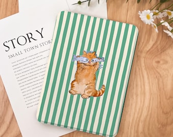 Puede incluir: Un cuaderno con una cubierta a rayas verdes y blancas que presenta un gato naranja de dibujos animados sosteniendo dos peces. El cuaderno está sobre una superficie de madera con un papel blanco y la palabra "STORY" impresa.