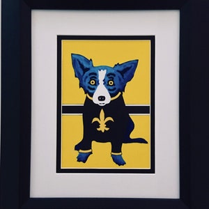 May include: A blue dog with a white chest and black eyes sits on a yellow background. The dog is wearing a black outfit with a fleur-de-lis on the chest. The dog is sitting on a black line.