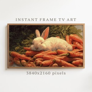 May include: A digital art print in a wooden frame, depicting a sleeping white rabbit on a bed of orange carrots. The image includes the text "INSTANT FRAME TV ART" and "3840x2160 pixels". The artwork has a vintage style.