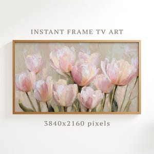 May include: A framed art print of pink and cream tulips, painted in an impressionistic style. The artwork has green stems and leaves. The text "INSTANT FRAME TV ART" is at the top. The frame is a warm gold color.