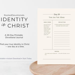 May include: A printable devotional journal titled "Identity in Christ" with the text "Day 19 You Are Not Alone." The journal includes space for Bible verses, reflection, and prayer. The journal is on a wooden tray.
