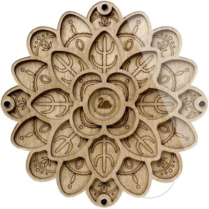 May include: A wooden, laser-cut decorative piece in a floral design. The piece is light brown with intricate patterns and a central logo. It features multiple layers and small magnets for assembly. The overall design is symmetrical and detailed.