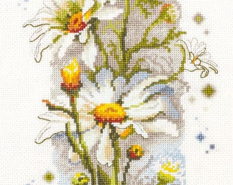 May include: A cross-stitch design featuring a bouquet of daisies. The flowers have white petals with yellow centers and red tips, set against a light gray and blue background. Green stems and buds complete the floral arrangement.