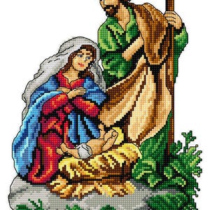 May include: A cross-stitch depiction of the Nativity scene. Mary, in a blue and red robe, cradles the baby Jesus in a manger. Joseph, in green and brown robes, stands behind them. The image is set against a white background with green foliage.