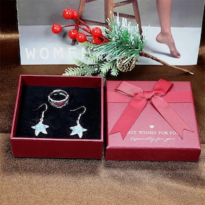 May include: A red gift box with a red bow and the text "Best Wishes For You Especially For You". The box contains a silver ring and a pair of silver earrings with blue and green stones.