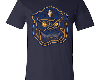 Könnte beinhalten: Ein kurzärmeliges T-Shirt in Marineblau mit einer Grafik eines Bulldogs, der eine Baseballkappe mit den Buchstaben AT trägt. Der Bulldog hat leuchtend gelbe Augen und ein breites Grinsen, umrandet von blau-goldenen Neonlinien.